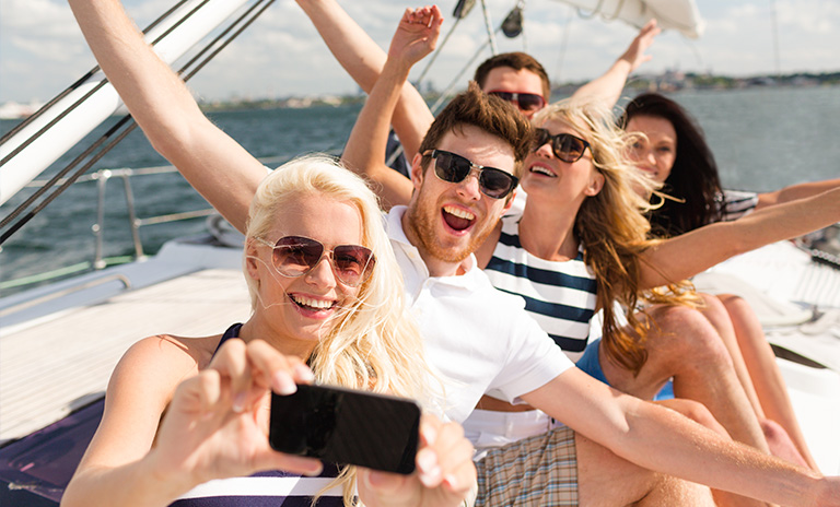 Grupo de amigos tomándose una selfie y teniendo una aventura en yate