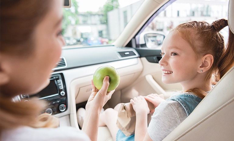 comiendo manzana en un carro seguro con una niña