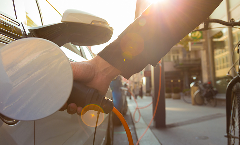 persona cargando uno de los carros con motor eléctrico