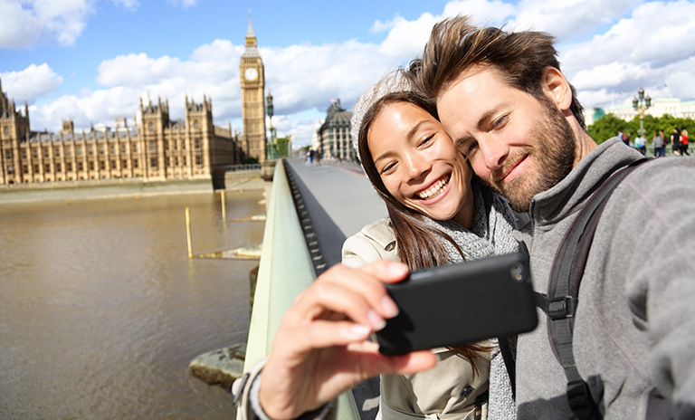 Una pareja haciéndose una selfie al borde de un puente