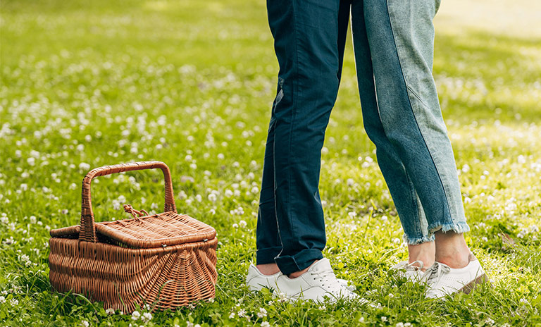 dos personas dándose un abrazo en medio de un picnic romántico