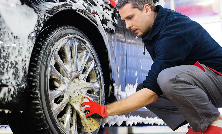 Hombre lavando carro uno de los beneficios de la comunidad Motorysa