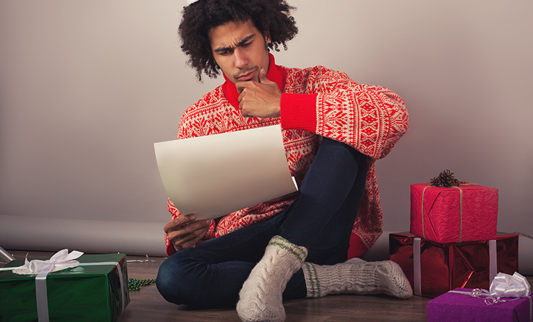 un hombre revisa una lista para comprar en navidad