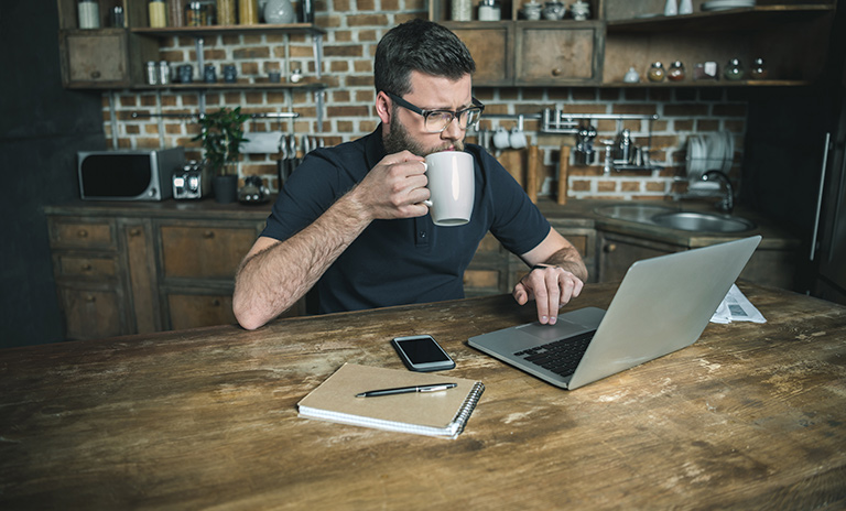 Hombre trabajando desde casa en su escritorio para mantener la productividad