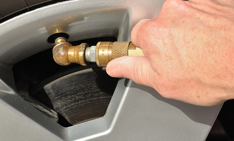 Hombre inflando las llantas de su auto