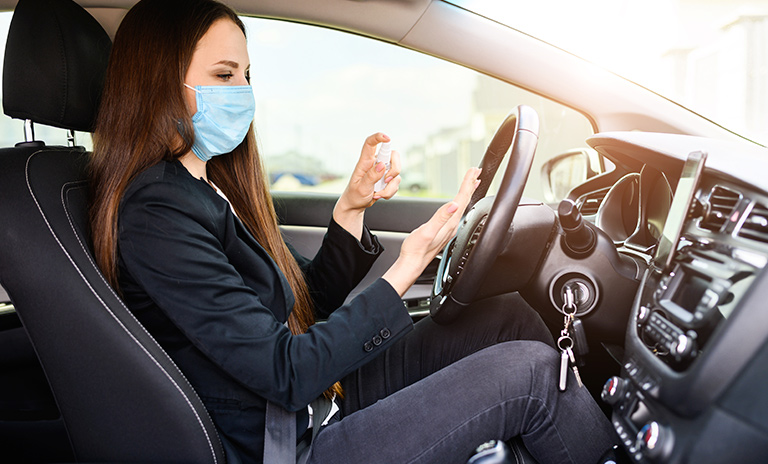 Mujer siguiendo las recomendaciones de bioseguridad para utilizar su vehículo.
