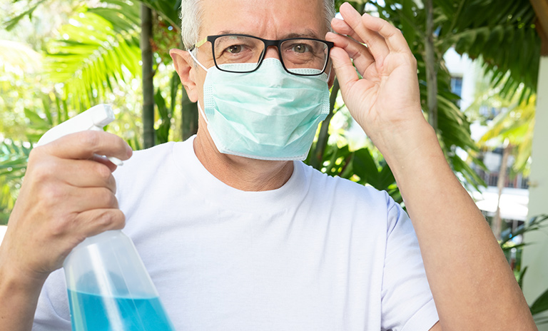 Hombre con spray de alcohol para cumplir las medidas de bioseguridad