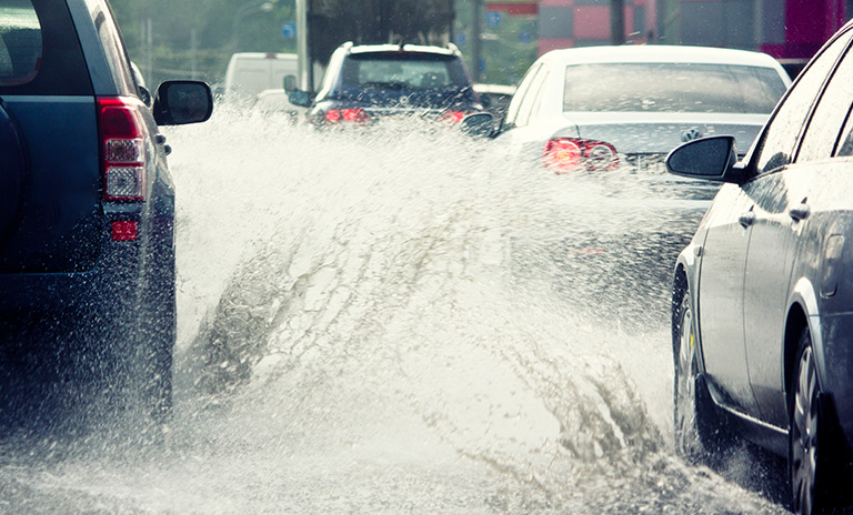 Persona aprendiendo a Conducir con lluvias fuertes y terrenos inundados