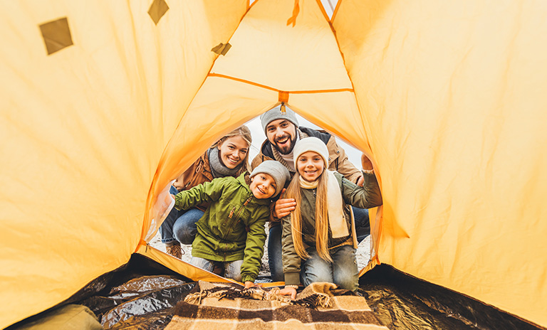 Familia mirando dentro de la tienda de camping