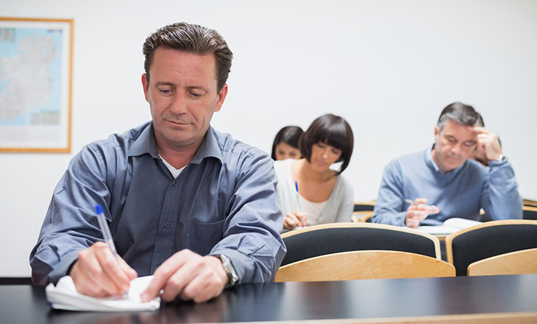 Hombre tomando nota en los cursos pedagógicos de movilidad en Bogotá