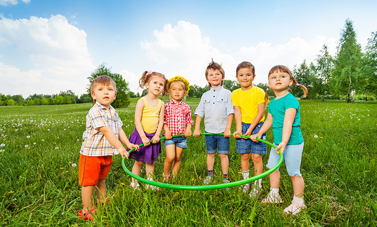 Niños tomados con un aro en el parque