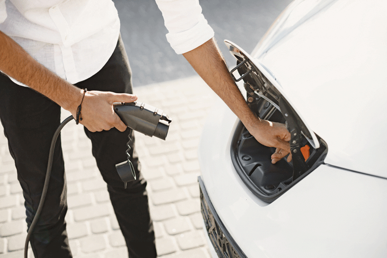 persona recargando un carro híbrido