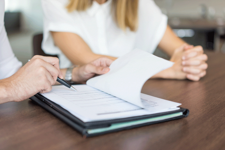 dos personas revisando un formulario de requisitos