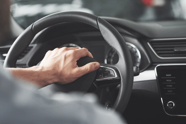 Persona conduciendo con las manos en el volante