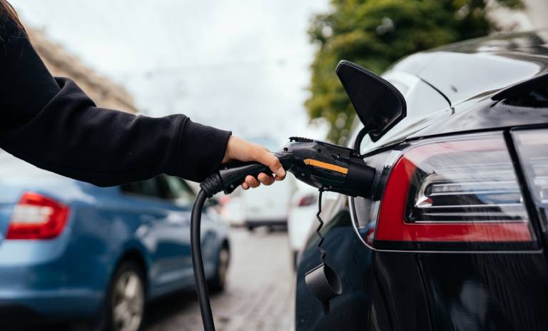 Persona que pone a cargar su carro eléctrico.