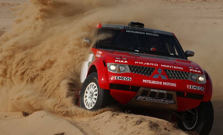 Camioneta Montero roja derrapando por el desierto