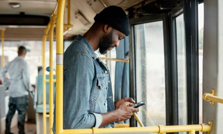 Persona revisando su celular mientras se desplaza en autobús 