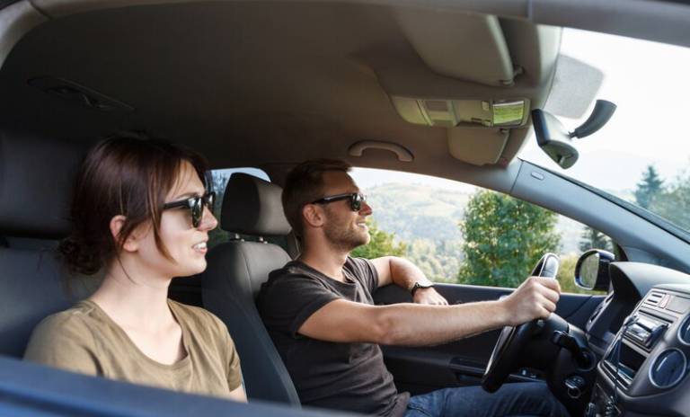 Dos personas con gafas de sol en el interior de un vehículo. 