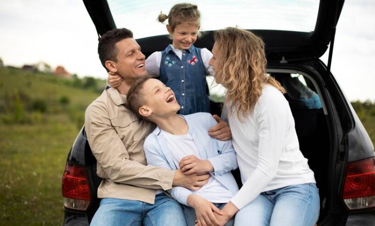 Familia disfrutando en la parte trasera de un carro 