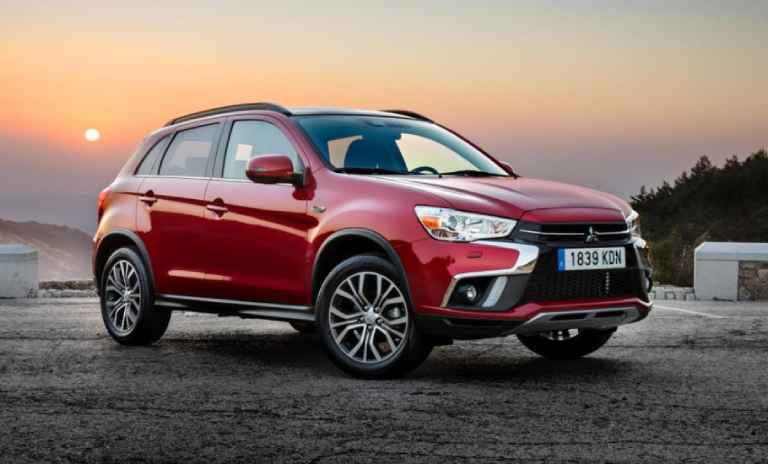 Una camioneta roja Mitsubishi y de fondo un paisaje