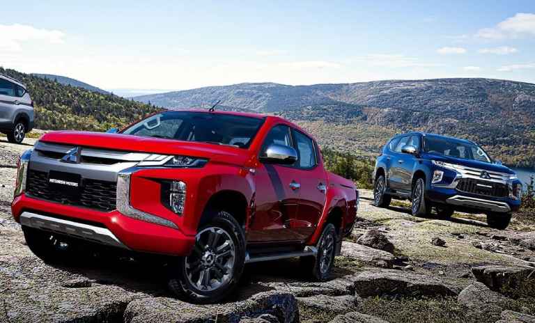 Dos camionetas Mitsubishi en montañas rocosas.